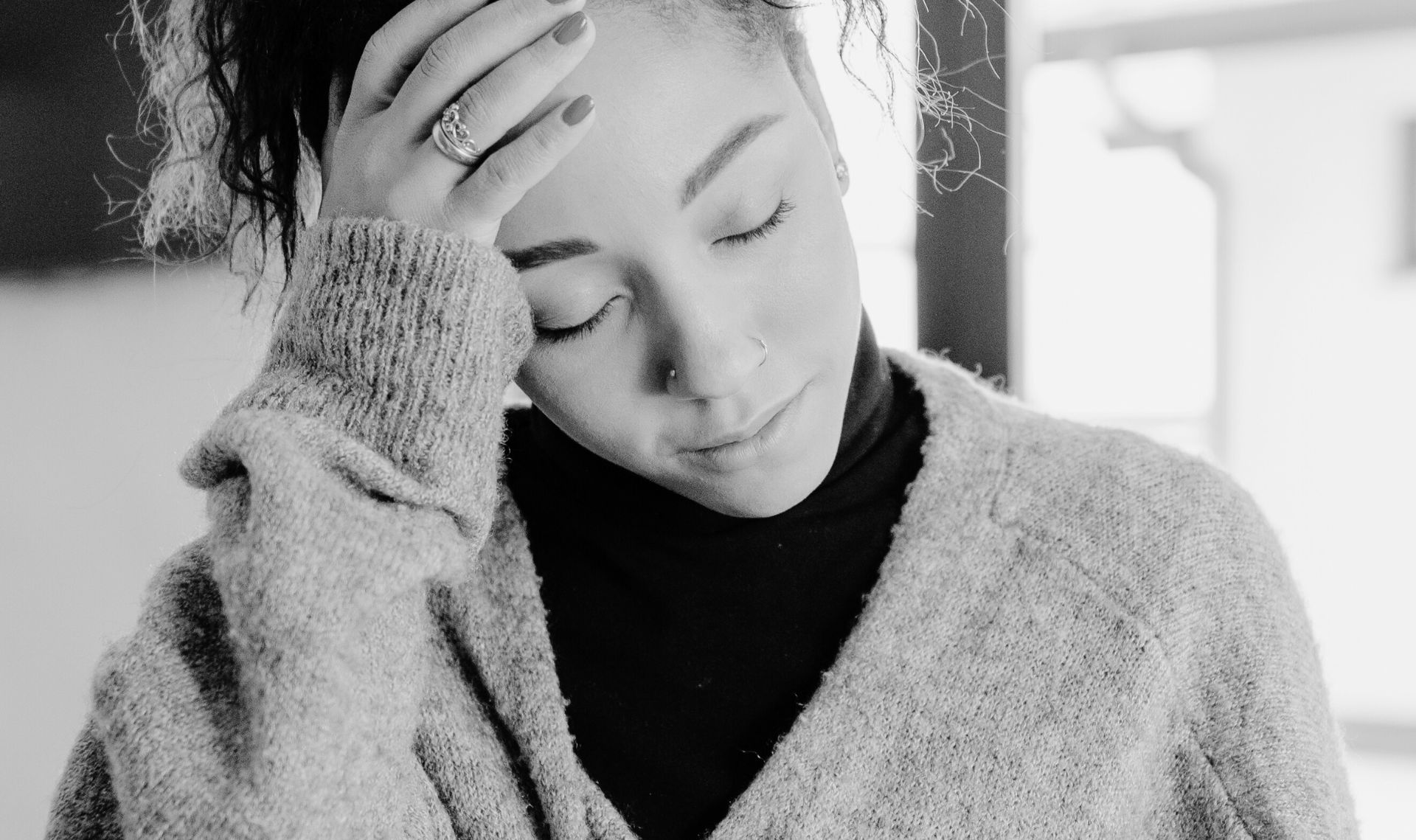 Woman resting and holding her head with her eyes closed