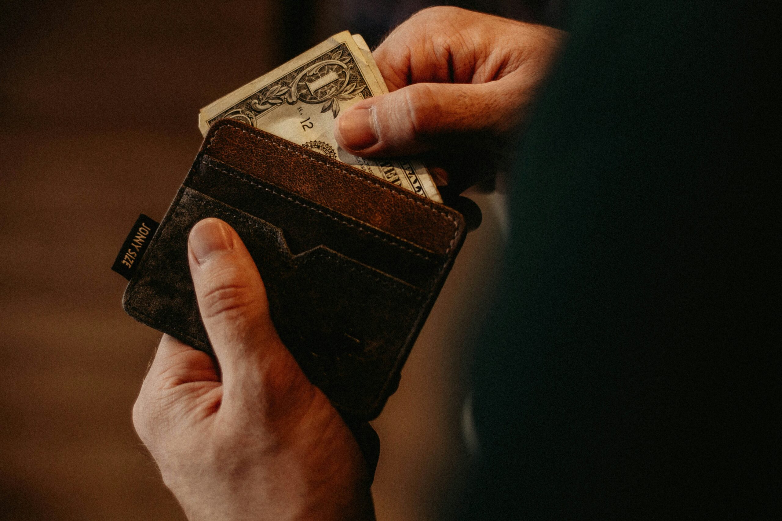 Hands pulling money out of a wallet for donations