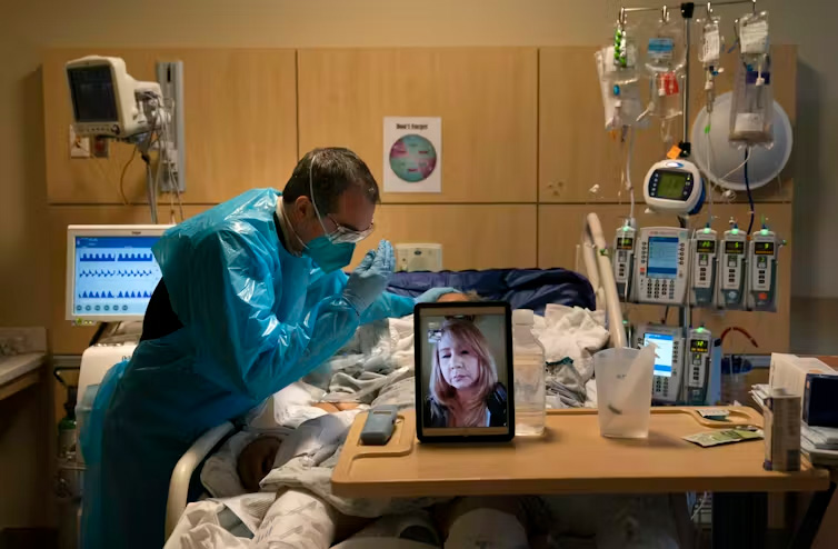 A chaplain prays for a COVID-19 patient in Los Angeles while on a video call with the patient’s daughter in November 2020. AP Photo/Jae C. HongWendy Cadge, Brandeis University and Michael Skaggs, Brandeis University